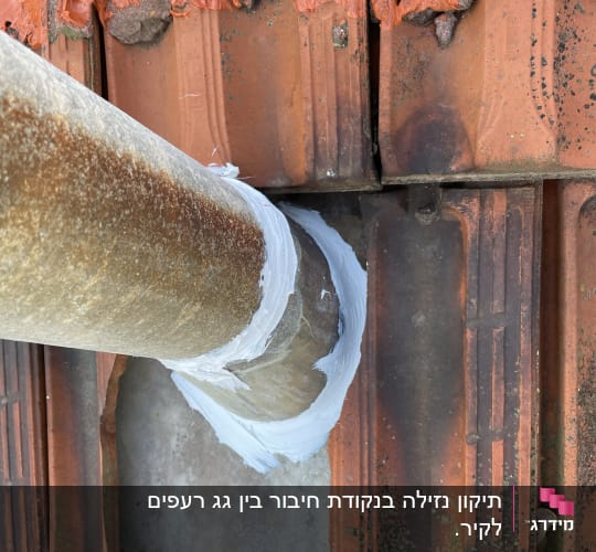 צינור מתכת עם איטום על גג רעפים כתום